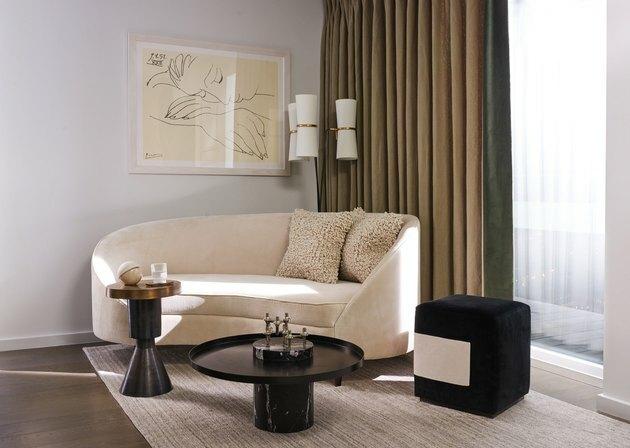 ruang tamu dengan tirai beludru dan sofa melengkung