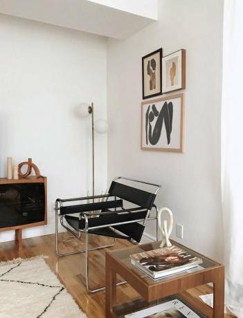 sala de estar mínima com cadeira bauhaus e pequena parede de galeria