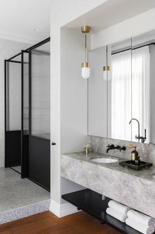 banheiro moderno branco com box de vidro e penteadeira de mármore cinza