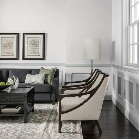 sala de estar com duas cadeiras e um sofá preto