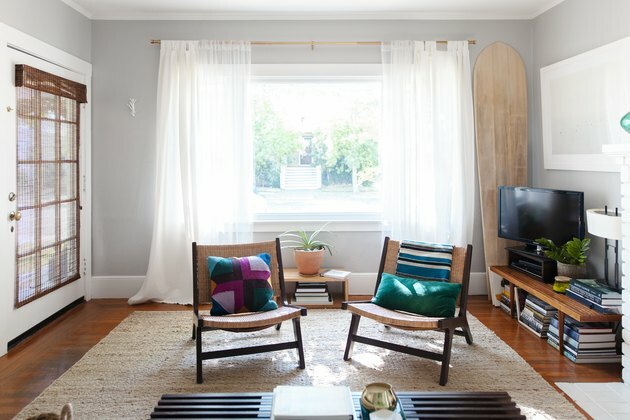 opholdsstue med to stole foran åbent vindue med rene gardiner