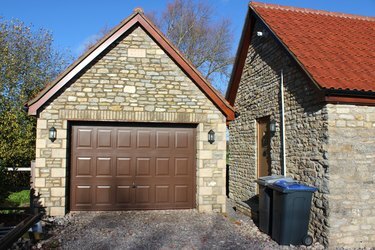 Immagine di garage indipendente, porta basculante, porta sul retro di un bungalow, bidoni della spazzatura