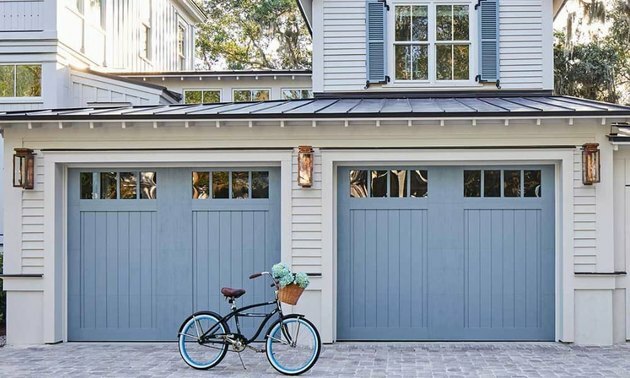 exterior da casa cinza com portas de garagem em estilo carruagem azul