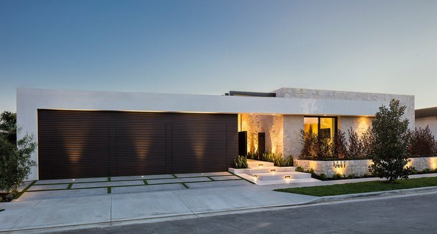 Iluminação exterior da garagem no exterior da casa moderna com garagem preta dividida