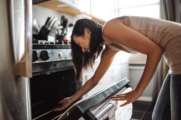 donna che tira fuori la torta dal forno