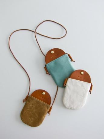 Drie canvas en leren crossbody tassen in verschillende kleuren: turkoois, bruin en wit