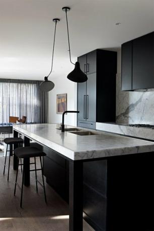 musta yksivärinen keittiö marmoritasoilla