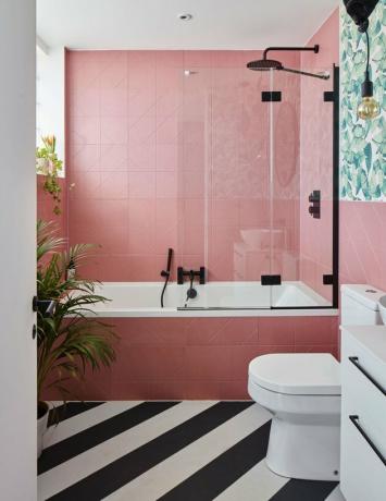 banheiro moderno com azulejos rosa e piso preto e branco