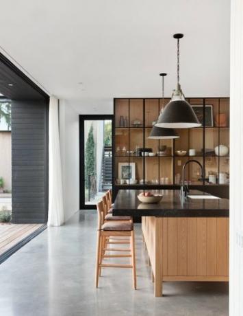 drvena i crna kuhinja sa staklenim prednjim ormarima i betonskim podovima