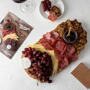 Tagliere di salumi con carne, frutta, cracker e formaggio