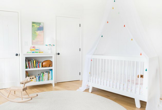 geheel witte minimalistische kinderkamer inrichting met wieg luifel