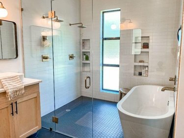 दो शावरहेड्स और एक बाथटब के साथ गीला कमरा