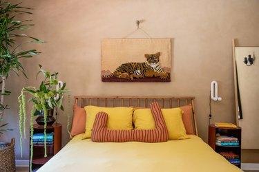 viesu guļamistaba ar romiešu māla sienu apstrādi un dzeltenu gultas veļu