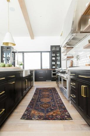 خزائن المطبخ الداكنة مع الأرضيات الخفيفة مع الأجهزة النحاسية والأرضيات الخشبية الخفيفة