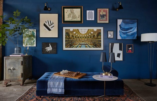 لون الطلاء الأزرق في جدار غرفة المعيشة مع جدار معرض وسرير نهاري
