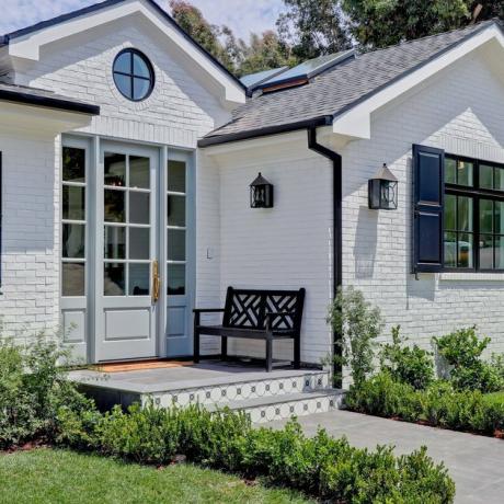 porta exterior guarnição na casa de tijolos brancos com porta azul e guarnição