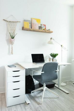 Área de escritório com mesa branca e cadeira cinza