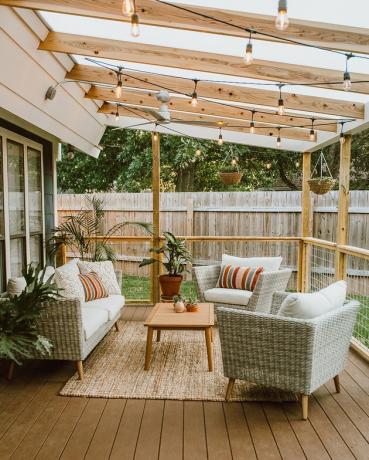 Pérgula contemporânea em ângulo de madeira em deck com móveis de exterior