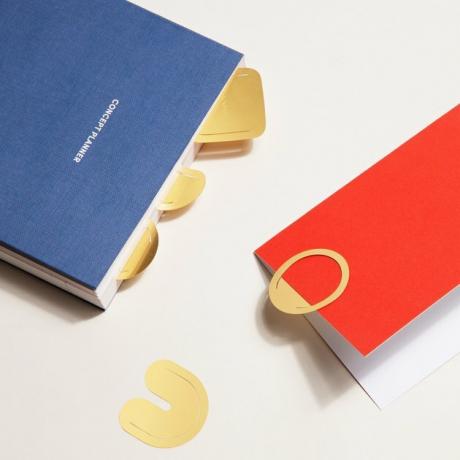 materiais de organização de escritório, livros vermelhos e azuis com clipes de papel dourados