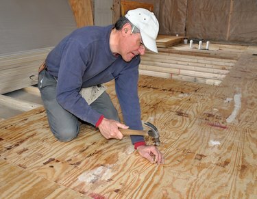 Hombre clavando contrapiso de madera contrachapada.