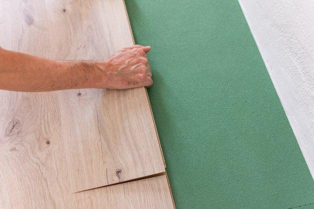 Lavoratore che installa la pavimentazione laminata di legno