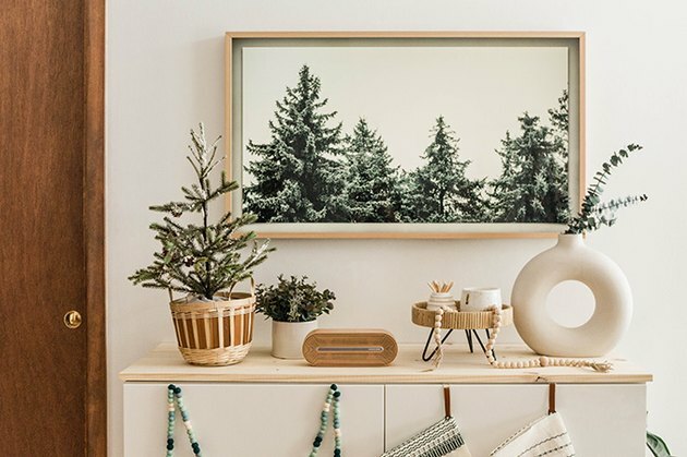 Arte na parede de pinheiro com vaso branco circular e toques modernos de decoração