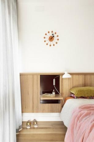 κύρια κρεβατοκάμαρα με ξύλινο κεφαλάρι και πολύχρωμα κλινοσκεπάσματα