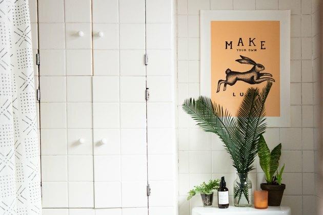 Mur de carreaux blancs dans la salle de bain, gros plan sur les plantes et l'affiche