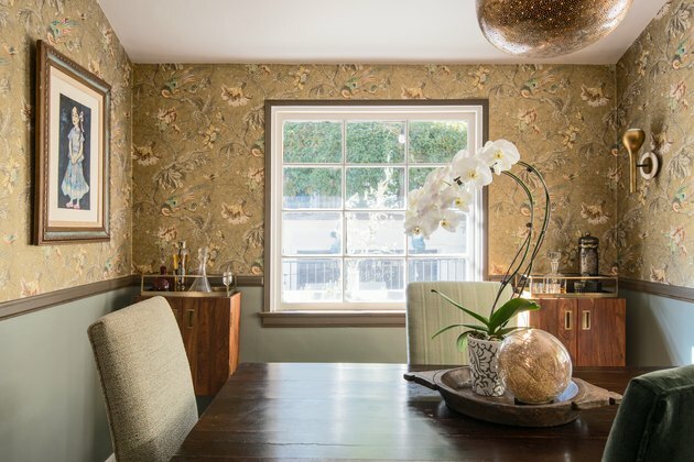 Sala da pranzo con carta da parati floreale e armadi in legno