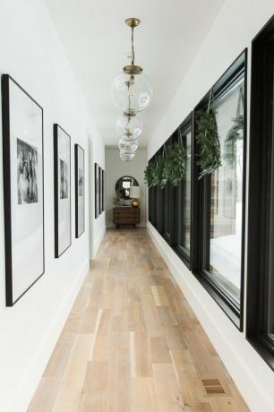 corredor branco com decorações de janela de Natal e luzes pendentes