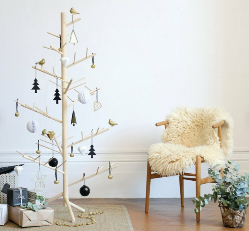 houten kerstboom met cadeautjes en wishbone stoel met schapenvacht