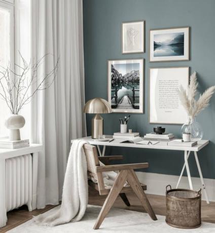 home office azul com uma parede acentuada e janelas brancas ao lado