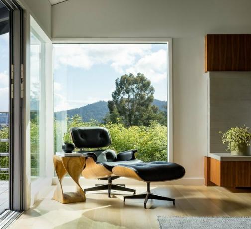 sedia moderna di metà del secolo vicino a una grande finestra di vetro
