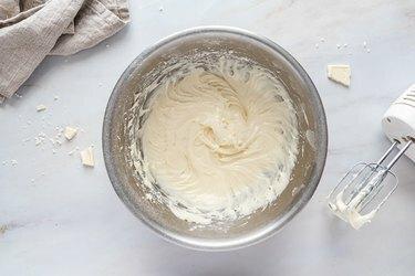 Glassa di formaggio cremoso in una ciotola di metallo.