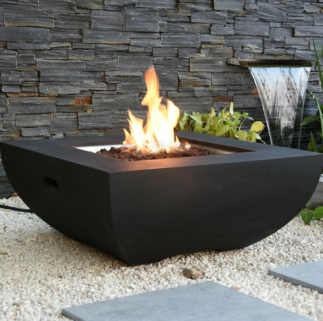 Mesa de fogo geométrica preta com fogo, cerca de pedra e cachoeira