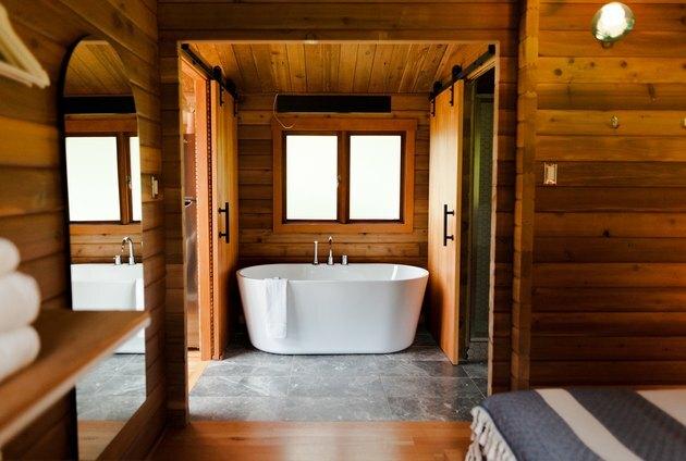 bañera independiente rodeada de madera natural y piedra