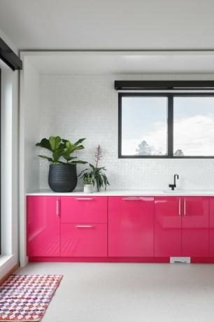 Hot pink kaapistot valkoisessa huoneessa vaaleanharmaalla lattialla