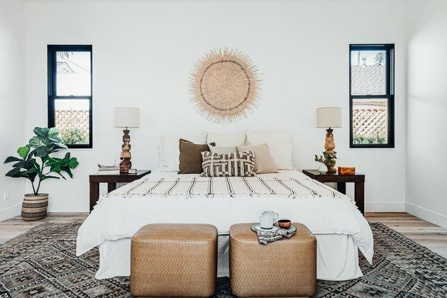 Quarto com decoração boho e cesta pendurada na cama.
