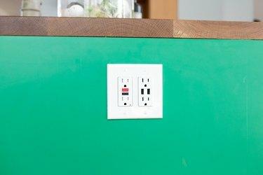 virtuves elektrības kontaktligzda uz zaļa fona