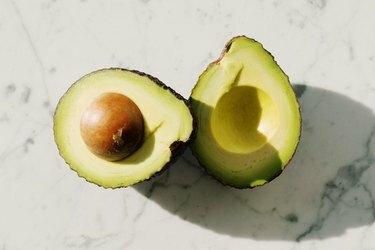 Avocado helften op een wit gemarmerde achtergrond