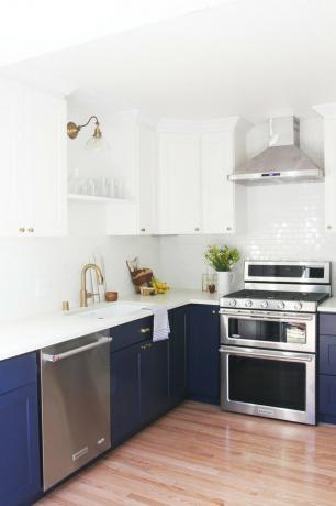 Wit en marineblauw keukenkleuridee met zilveren apparaten en witte tegel backsplash