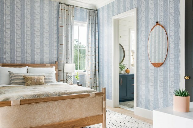 papel de parede da pervinca e cama de couro no quarto costeiro