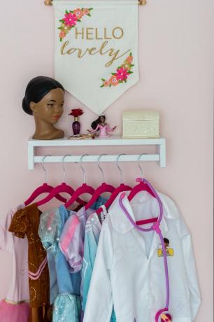 Organização do quarto infantil com paredes rosa e área de vestir