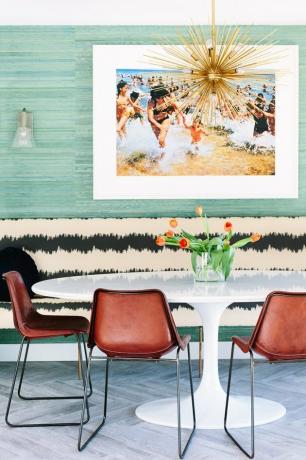 Sala de jantar eclética com mesa em tulipa Saarinen, cadeiras marrons e banqueta estampada