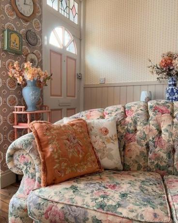 svetainė su gėlių sofa ir tapetais