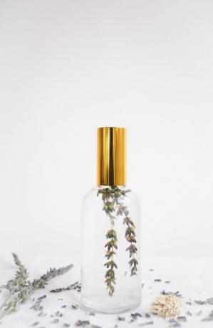 ضباب وسادة DIY في زجاجة زجاجية مع قمة ذهبية وغصن من اللافندر في الداخل