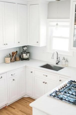 hvitt kjøkken med vask og vindu i rustfritt stål