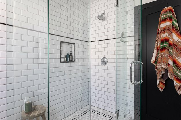 Chuveiro com ladrilhos do metrô e piso em azulejo preto e branco