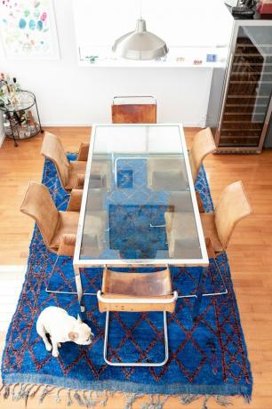 Mesa de comedor de vidrio con sillas de cuero.