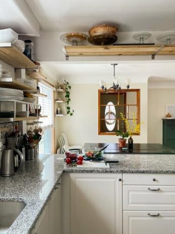 Kuhinja Summar Saad s bijelim ormarima s otvorenim policama i granitnim pločama